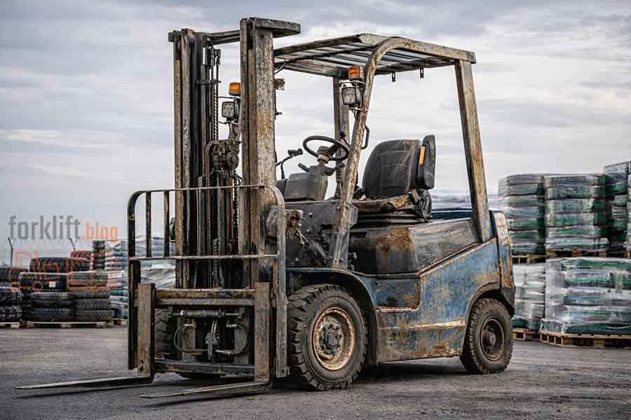 Старый изношенный вилочный погрузчик с коррозией и повреждениями, подлежащий утилизации и замене на новую складскую технику