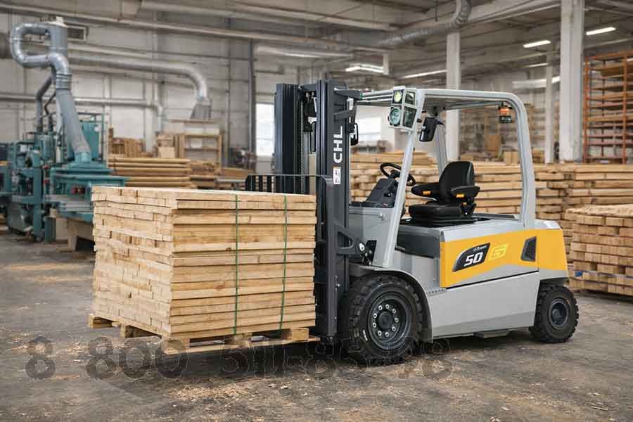 Вилочный погрузчик средней грузоподъёмности перемещает стопки пиломатериалов внутри деревообрабатывающего производственного цеха
