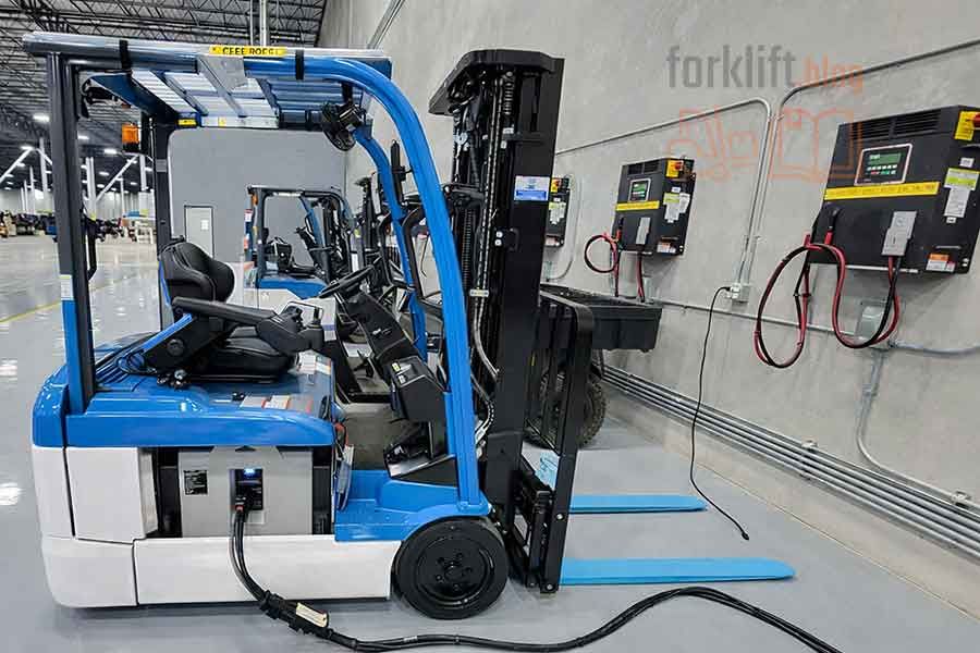 Электрический вилочный погрузчик проходит зарядку в оборудованной зоне склада, обеспечивая готовность техники к сменной и интенсивной работе